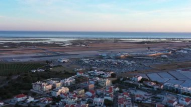 Aerial view of Portuguese Faro Airport, airplanes and runways against the sea. On the Sunset. High quality 4k footage