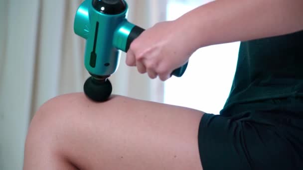 Girl Athlete Uses Modern Massage Gun Therapeutic Relaxation Thigh Fight — Vídeo de Stock