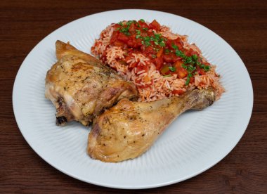 Leg of chicken in Provencal sauce with rice and tomato puree. With wooden background. High quality photo