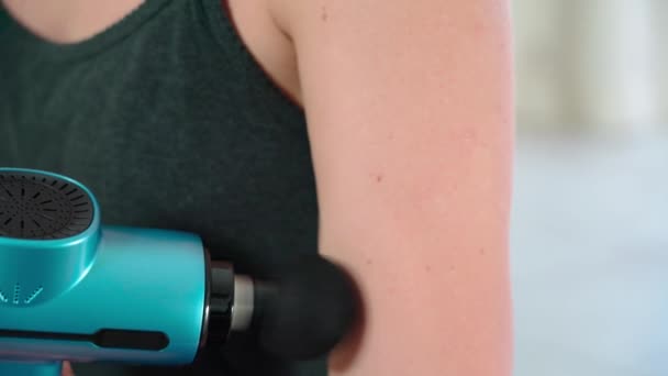 Ung Kvinnlig Idrottsman Använder Modern Massage Pistol För Terapeutisk Avkoppling — Stockvideo