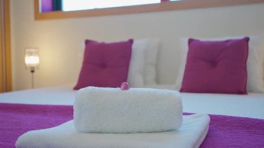 Luxurious bedroom in a villa hotel. White towels on the bed. High quality 4k footage