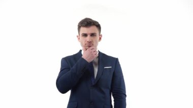 Handsome male businessman in a suit conceived about solving a problem. Neutral emotions in the studio on a white background. High quality FullHD footage