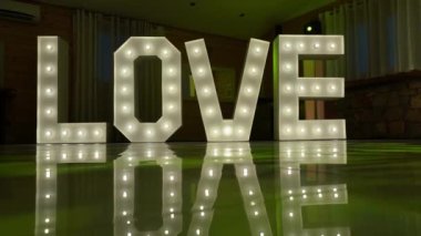 Decorative word from luminous lamp letters love at the wedding and Valentines day. Glowing inscription. High quality 4k footage