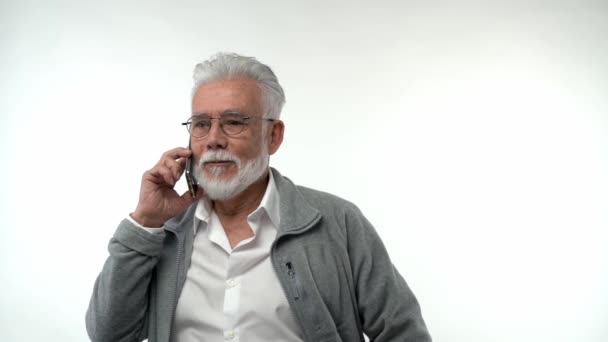 Porträtt Äldre Pensionerad Man Glasögon Talar Mobiltelefon Vit Bakgrund Gråhårig — Stockvideo
