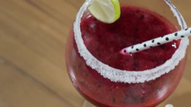 Cocktail alcoholic drink juice in a glass with a straw. Movement back. Close-up. High quality 4k footage