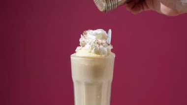 The barista prepares coffee ice cream from chantilly, sprinkles with cinnamon and puts a cherry. High quality 4k footage