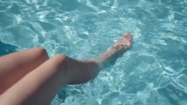 Otelde dinlenirken kızların havuzda turkuaz suyla yaptıkları hareketler.