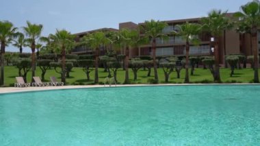 Mavi berrak su ve doğa ile yüzme havuzu olan bir otel. Avuçlar. Yüksek kalite 4k görüntü