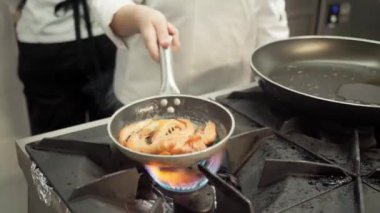 Şef kızartma tavasında lezzetli bir kızarmış karides tabağı hazırlıyor. Yüksek kaliteli FullHD görüntüler