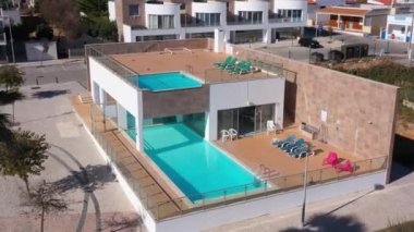 Otelin havuz manzarasında turistler için güneşli yataklarla modern yüzme havuzu kompleksi. Portekiz. Yüksek kalite 4k görüntü