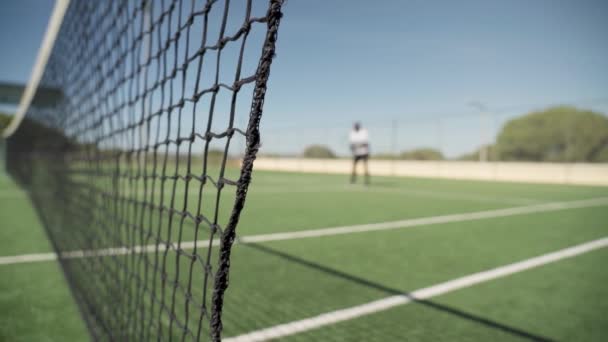 Теннисист Играет Теннис Заднем Плане Размытом Виде Сетка Находится Переднем — стоковое видео