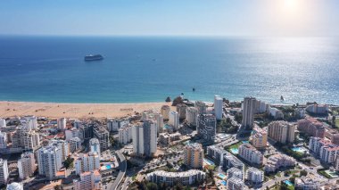Portekiz 'in Portimao şehrinin plajlı yüksek binaları ile hava manzarası. Turist yolcu gemisi denizde arka planda. Yüksek kalite fotoğraf