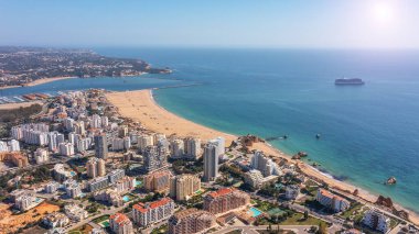 Portekiz 'in Portimao şehrinin plajlı yüksek binaları ile hava manzarası. Turist yolcu gemisi denizde arka planda. Yüksek kalite fotoğraf