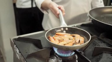 Şef kızartma tavasında lezzetli bir kızarmış karides tabağı hazırlıyor. Yüksek kaliteli FullHD görüntüler