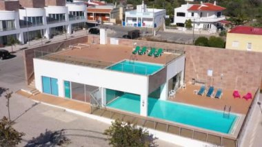 Otelin havuz manzarasında turistler için güneşli yataklarla modern yüzme havuzu kompleksi. Portekiz. Yüksek kalite 4k görüntü