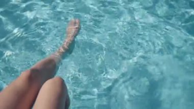 Otelde dinlenirken temiz turkuaz suyla havuzda ayak hareketleri. Yüksek kaliteli FullHD görüntüler