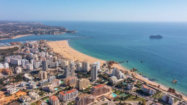 Portekiz 'in Portimao şehrinin plajlı yüksek binaları ile hava manzarası. Turist yolcu gemisi denizde arka planda. Yüksek kalite fotoğraf