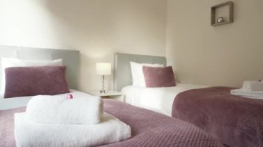 Basit bir tasarımı olan, dinlenmek ve uyumak için yatağı olan modern, rahat bir yatak odası. Yüksek kalite 4k görüntü