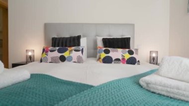 Basit bir tasarımı olan, dinlenmek ve uyumak için yatağı olan modern, rahat bir yatak odası. Yüksek kalite 4k görüntü