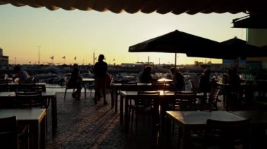 Faro şehir merkezi kafe restoranı Coreto, müşteriler gün batımında akşam yemeği için oturuyor. 27 Mart 2022 Faro Portekiz. Yüksek kalite 4k görüntü