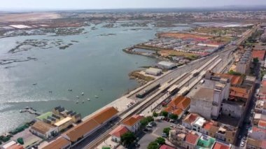 Faro şehrinin, tren istasyonunda uçan bir insansız hava aracı ve tuz çıkarmak için göller üzerindeki hava görüntüleri. Portekiz Algarve. Yüksek kalite 4k görüntü