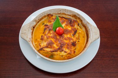 Ev yapımı vejetaryen lazanya, domates ve fesleğen soslu ahşap masa. Yüksek kalite fotoğraf