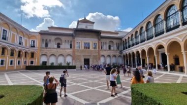 Sevilla 'daki Alcazar Sarayı' nın bahçesinin önündeki meydanda bir turist kalabalığı. Sevilla İspanya 15 Nisan 2023. Yüksek kaliteli FullHD görüntüler