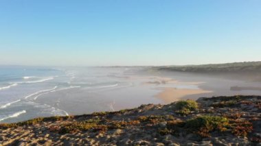 Portekiz 'de güneş doğarken Praia do Malhao sahilinin sisli ve sisli görüntüsü. Yüksek kalite 4k görüntü