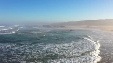 Portekiz 'de güneş doğarken Praia do Malhao sahilinin sisli ve sisli görüntüsü. Yüksek kalite 4k görüntü