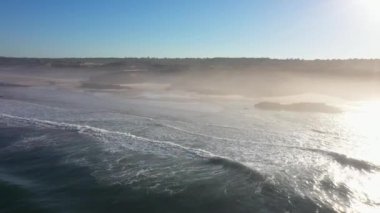 Portekiz 'de güneş doğarken Praia do Malhao sahilinin sisli ve sisli görüntüsü. Yüksek kalite 4k görüntü