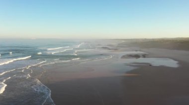Portekiz 'de güneş doğarken Praia do Malhao sahilinin sisli ve sisli görüntüsü. Yüksek kalite 4k görüntü