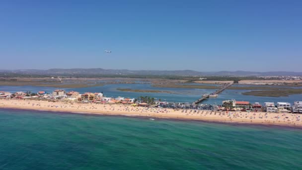 海岸とビーチの空中ビュー 水上ボートやドローンから見たビーチでリラックスする観光客 プライア ファロ アルガルヴェ ポルトガル 高品質の4K映像 — ストック動画