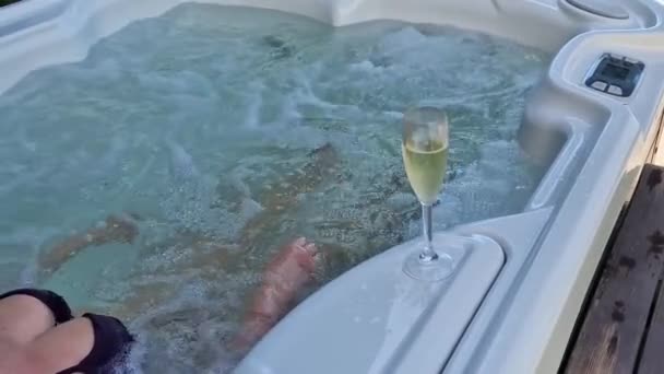 熱い渦巻き風呂の女性はリラックスするためにシャンパンのグラスを取ります 中間プラン 高品質のフルHd映像 — ストック動画