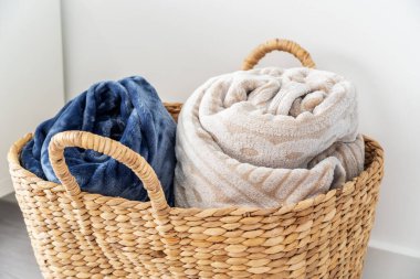 Hasır bir sepet, yün battaniyeleri ekose kumaşlara sarar. Kışın seni sıcak tutmak için. - Evet. Yüksek kalite fotoğraf