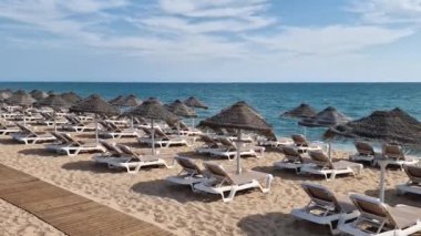 Turistler için güneşlik ve şemsiyeli plaj manzarası harika. Yüksek kaliteli FullHD görüntüler