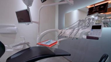 El aletleri, hava kabartma, dokunmatik ekran kontrol paneli, montajlı monitör ve parlak ışıklandırmalı ergonomik sandalye de dahil olmak üzere diş aletlerinin yakın plan görüntüleri.