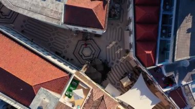 Portekiz, Faro 'daki Rua de Santo Antonio' nun tepeden aşağı hava görüntüsü, kırmızı kiremitli çatıları, desenli yaya yolları ve şehir meydanı olan tarihi binaları gösteriyor..