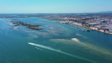 Olhao Portekiz 'in nefes kesici insansız hava aracı görüntüsü çarpıcı Ria Formosa' yı mavi sularda beyaz izler bırakan karmaşık kumsaldaki sürat tekneleriyle gösteriyor.