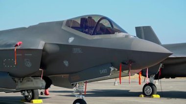 Beja Portekiz 2 Haziran 2024 Hava Gösterisi havaalanına park etmiş bir F-35 Lightning II savaş uçağı yakın çekim görüntüsü gelişmiş tasarımı, güvenlik şeritleri ve görünür kokpit yansımaları sergilenmektedir.