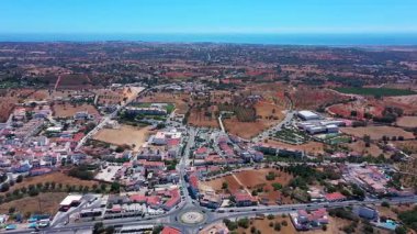 Guia 'nın Albufeira, Portekiz' deki hava aracı görüntüleri kıyı şeridine doğru uzanan konut ve ticari binaların, yolların, tarım alanlarının ve yeşil alanların karışımını gösteriyor..