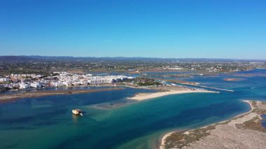 Fuseta Portekiz 'in havadan görünüşü Ria Formosa lagününün turkuaz sularla kumlu sahilleri küçük adaları bir kıyı kasabasını gösteriyor.