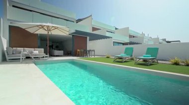 Şatafatlı bir villa özel bir yüzme havuzu, güneş pansiyonları, şemsiye ve manikürlü bir çim sergiliyor. Rahatlama ve rahatlama için mükemmel bir ortam sunuyor.