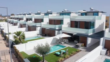 Özel turkuaz havuzlar, manikürlü yeşil çimenler ve lüks Akdeniz yaşam tarzı ve gayrimenkul tasarımını tanımlayan modern mimarinin yer aldığı el değmemiş beyaz konut villaları.