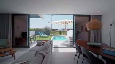 Modern iç tasarımı sergilenen lüks villa, açık planlı yaşam alanı, ve güneş panelleri ve bahçe mobilyalarıyla özel yüzme havuzu, rahatlatıcı ve davetkar bir atmosfer yaratıyor.