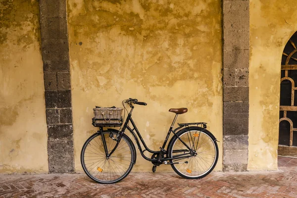 A bicycle leaning against the wall inside Saint Francis cloister in Sorrento, Italy