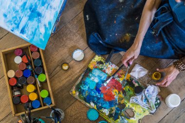 Fırçaların, paletlerin, yağların, akriliklerin ve bir ressamın diğer elementlerinin yüksek açılı görüntüsü. Sanat atölyesi. Arkaplan.