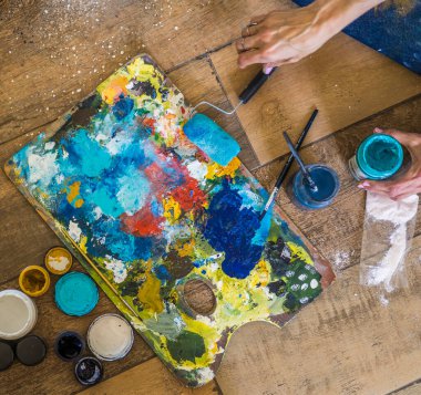 Fırçaların, paletlerin, yağların, akriliklerin ve bir ressamın diğer elementlerinin yüksek açılı görüntüsü. Sanat atölyesi. Arkaplan.