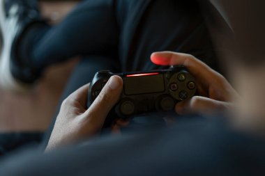 Yetişkin bir adamın elinde joystick tutarken konsolda video oyunu oynarken yakın plan fotoğrafı..