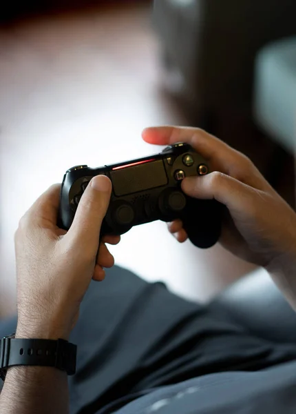 stock image High angle view of an adult man's hands holding a joystick while playing a video game on a console