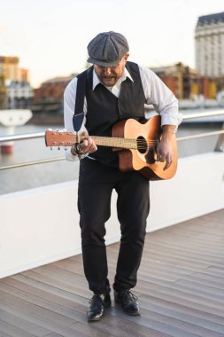 Gitarist sokakta gitar çalıyor.